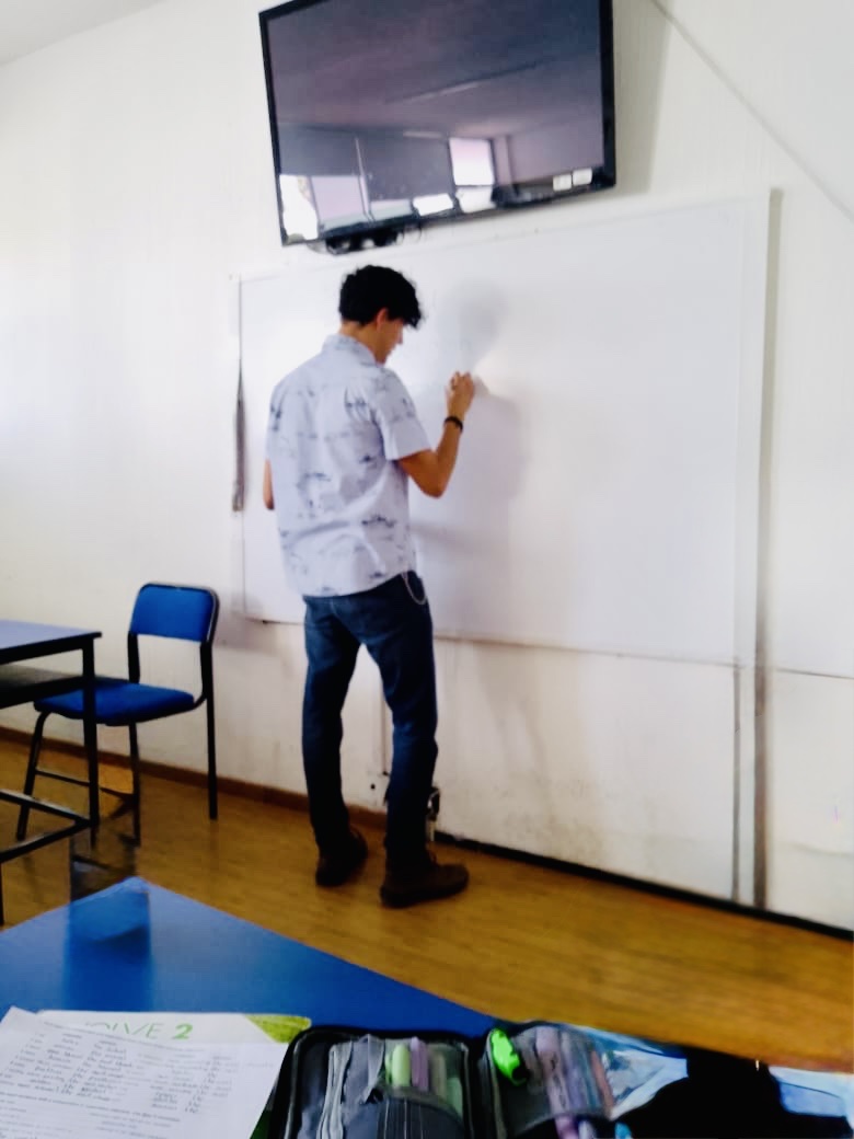 Omar dando clase frente a un grupo, en el aula